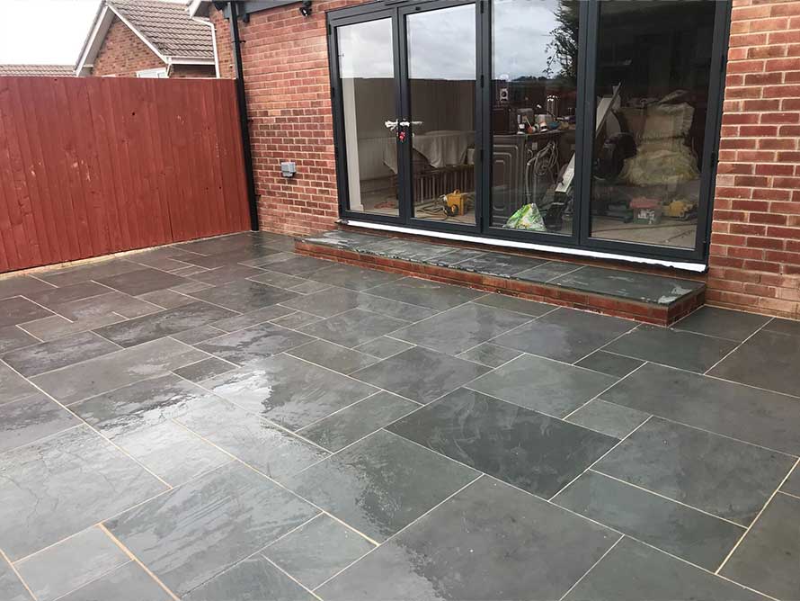 Patios- A picture of a newly laid patio with grey slanted slabs